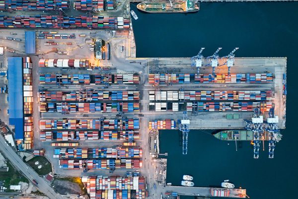 Aerial view of a container port with cargo ships and gantry cranes used in marine shipbuilding steel applications