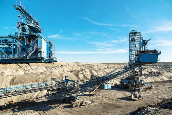 Open-pit mining site with heavy steel machinery and conveyor belts used in mineral processing
